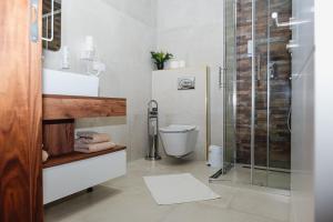 a bathroom with a toilet and a glass shower at Edemus - Motel & Restaurant in Maglaj