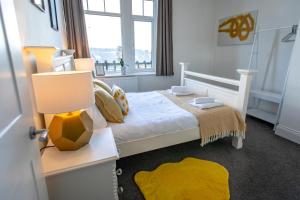 a bedroom with a bed with a lamp and a yellow rug at The Ilkley Retreat in Ilkley