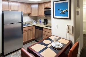 a kitchen with a stainless steel refrigerator and a table at Residence Inn by Marriott Seattle Downtown/Lake Union in Seattle
