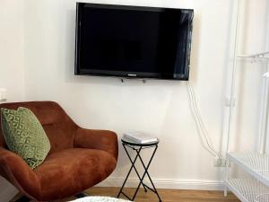a living room with a chair and a flat screen tv at DLC exklusives Studio im Zentrum in Bad Pyrmont