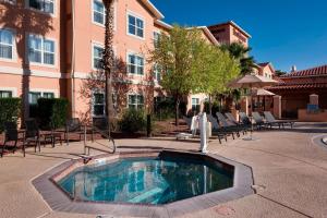 Residence Inn Tucson Airport في توسان: مسبح في ساحة مع كراسي ومبنى