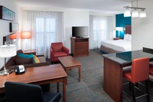 a hotel room with a bed and a desk and chairs at Residence Inn Tucson Airport in Tucson