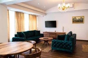 a living room with green furniture and a tv at Edemus - Motel & Restaurant in Maglaj