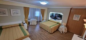 a hotel room with two beds and a mirror at Gavilanes 2 TOLEDO in Toledo