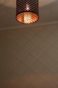 An einer Decke in einem Zimmer hängender Aandelier in der Unterkunft Landhotel Eifellust in Schalkenmehren