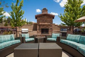 a patio with chairs and a brick fireplace at Residence Inn Prescott in Prescott