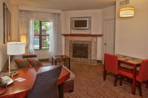 sala de estar con mesa y chimenea en Residence Inn Prescott, en Prescott