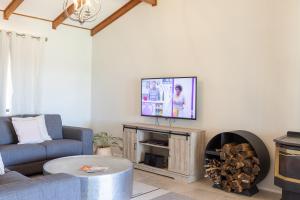 a living room with a couch and a tv at Hunter Gleann Pty Ltd in Pokolbin