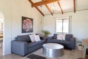 a living room with two couches and a table at Hunter Gleann Pty Ltd in Pokolbin