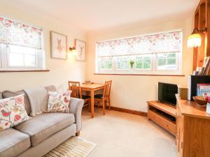 a living room with a couch and a tv and a table at Hunters Lodge in Norwich