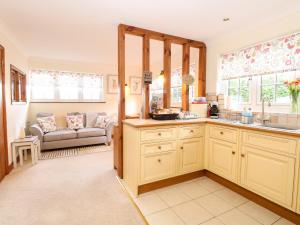 - une cuisine avec un canapé dans le salon dans l'établissement Hunters Lodge, à Norwich