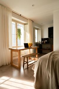 a bedroom with a table with a laptop on it at Casa Uva - Boutique Guest House in Vejer de la Frontera