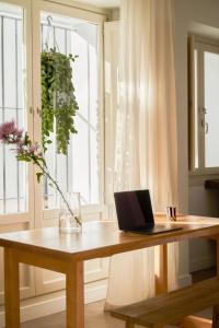 einen Laptop auf einem Holztisch vor einem Fenster in der Unterkunft Casa Uva - Boutique Guest House in Vejer de la Frontera