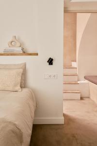 sypialnia z białymi ścianami, łóżkiem i schodami w obiekcie Casa Uva - Boutique Guest House w mieście Vejer de la Frontera