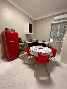eine Küche mit einem roten Kühlschrank sowie einem Tisch und Stühlen in der Unterkunft Sant'Alfonso Home in Portici