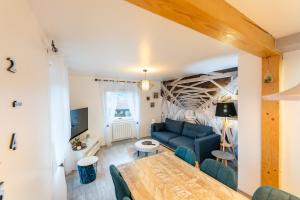 a living room with a blue couch and a table at Gîte l'Améthyste 3 appartements in Gérardmer