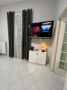 ein Wohnzimmer mit einem TV und einem weißen Boden in der Unterkunft Sant'Alfonso Home in Portici