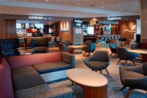 a lobby with a couch and chairs and a bar at Courtyard by Marriott Detroit Downtown in Detroit