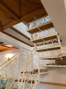 a spiral staircase in a home with a white railing at Rustic Retreat by Roamhome - Modern 2BHK Apartment near Naini Lake in Nainital