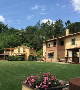 einen großen Hof mit einem Gebäude und Blumen in der Unterkunft Agriturismo Podere Bucine Basso in Lari
