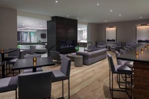 a living room with tables and chairs and a fireplace at SpringHill Suites by Marriott Indianapolis Westfield in Westfield