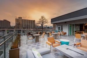 Element Dallas Downtown East في دالاس: فناء على السطح مع طاولات وكراسي على مبنى