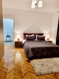 a bedroom with a large bed with two lamps at Cozy apartment near city center in Bucharest