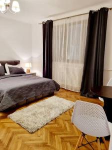 a bedroom with a bed and a table and a chair at Cozy apartment near city center in Bucharest