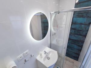 W białej łazience znajduje się umywalka i lustro. w obiekcie Konik Morski w Jastarni