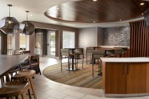 a restaurant with wooden tables and bar stools at SpringHill Suites Dallas Arlington North in Arlington