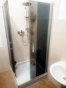 a shower with a glass door next to a toilet at Kwatery Mińsk Mazowiecki in Mińsk Mazowiecki