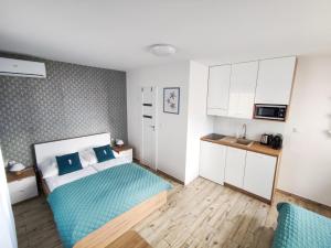 een kleine kamer met een bed en een keuken bij Konik Morski in Jastarnia