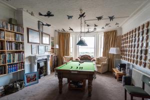 a living room with a pool table in it at OYO Lord Kitcheners Guest House in Lowestoft