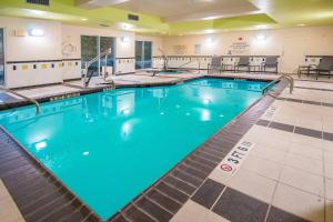 a large swimming pool with blue water in a building at Fairfield Inn & Suites by Marriott San Antonio North/Stone Oak in San Antonio