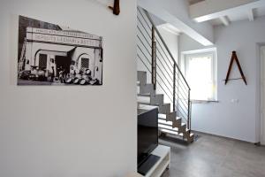 uma escada num quarto branco com uma fotografia na parede em La Casa del Bottaio em Lucca