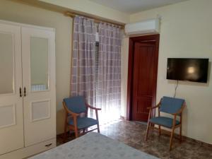 a living room with two chairs and a television at Hostal Rural Gloria in Graena