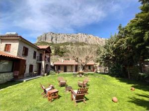 un cortile con sedie e una montagna sullo sfondo di Theopetra a Theópetra