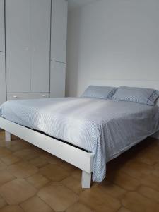 uma cama branca num quarto com uma parede branca em Mira Holiday em Mira