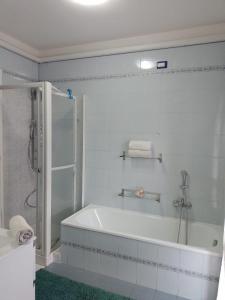 uma casa de banho branca com uma banheira e um chuveiro em Mira Holiday em Mira