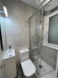 een badkamer met een douche, een toilet en een wastafel bij Céntrico y acogedor piso con garaje in A Coruña