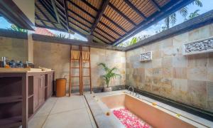een grote badkamer met een bad in de kamer bij Villa Dihati in Tabanan