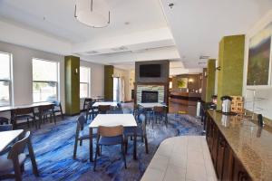 a dining room with tables and chairs and a fireplace at Fairfield Inn & Suites by Marriott Grand Junction Downtown/Historic Main Street in Grand Junction