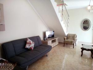 a living room with a couch and a tv at Evis Maisonette with sea view in Flogita