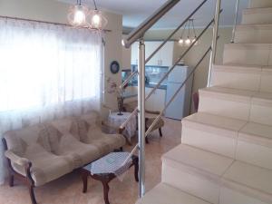 a living room with a couch and a staircase at Evis Maisonette with sea view in Flogita