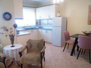 a kitchen with a table and a white refrigerator at Evis Maisonette with sea view in Flogita +12 photos