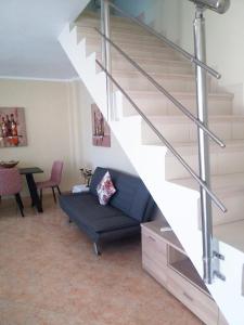 a living room with a blue couch under a staircase at Evis Maisonette with sea view in Flogita