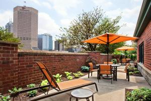 a patio with tables and chairs and an umbrella at Courtyard Indianapolis at the Capitol in Indianapolis