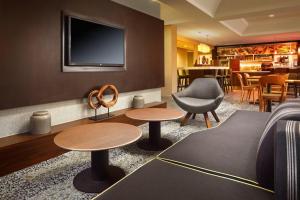 a hotel room with two tables and a tv at Courtyard Indianapolis at the Capitol in Indianapolis