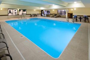 duży basen z niebieską wodą w pokoju hotelowym w obiekcie Courtyard Indianapolis at the Capitol w mieście Indianapolis