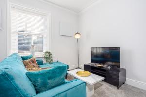 a living room with a blue couch and a tv at Coppergate Mews Grimsby No7 - 2 bed, 2 bath, 1st floor apartment in Grimsby